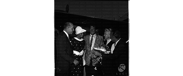 Dean Martin all'aeroporto di Ciampino, accanto a lui una donna bionda, forse la moglie,alla destra dell'attore c'è l'attrice Eva Bartok e altri due uomini - piano americano
