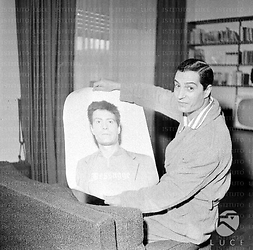 Manfredi nella sua casa mostra una sua foto - piano medio