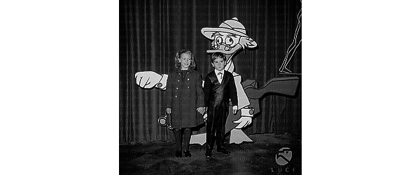 Il figlio di Gina Lollobrigida ed un'altra bambina davanti alla gigantografia del personaggio dei cartoni animati Pico de Paperis - totale