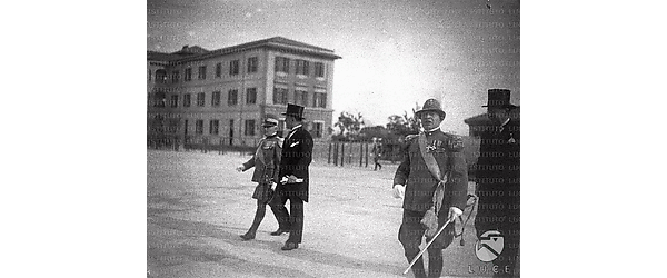 Roma Benito Mussolini e Antonio Mosconi passeggiano, accompagnati da autorità militari della guardia di finanza, per un cortile