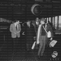 Romolo Marcellini cammina all'interno dell'aeroporto di Fiumicino con alcune persone; campo medio