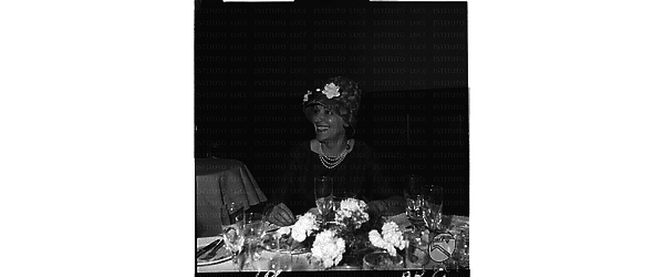In occasione della comunione, ripresa seduta al tavolo del ristorante una donna sorridente - piano medio