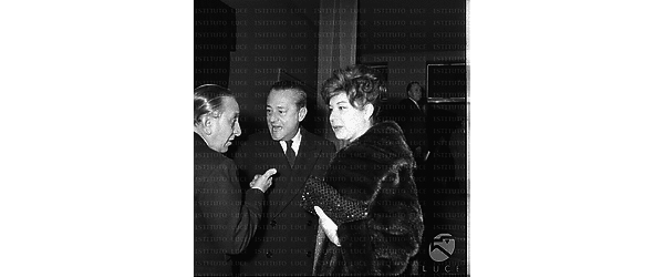 Un uomo, Sandro Pallavicini ed una donna (forse la moglie) ripresi all'arrivo al cinema Archimede in occasione della prima del film La Parmigiana - piano americano
