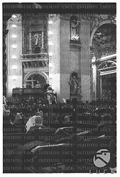 Il papa Giovanni XXIII seduto su una poltrona è portato in spalla all'interno della basilica di San Pietro dove gremita di malati sdraiati su una lettiga - campo medio