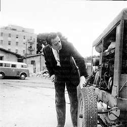 Carlo D'Angelo in una rimessa controlla la ruota di un automezzo