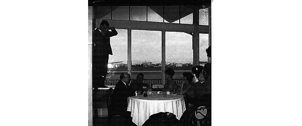 Pascale Petit e Marcel Carné seduti ad un tavolino nell'aeroporto di Ciampino. Campo medio