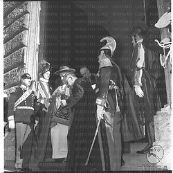 Il papa Giovanni XXIII ripreso mentre esce dall'università Gregoriana. Sulle scale ci sono dei poliziotti e delle gardie svizzere sugli attenti. Totale