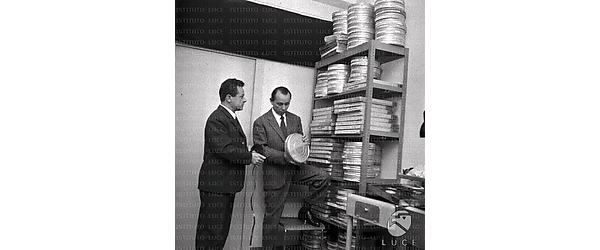 Carlo Alberto Chiesa verifica l'etichetta di una scatola, accanto ad un tecnico, Totale