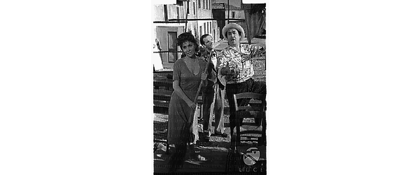 Gina Lollobrigida con una scopa in mano insieme a due attori sul set del film 'Pane amore e gelosia' - totale
