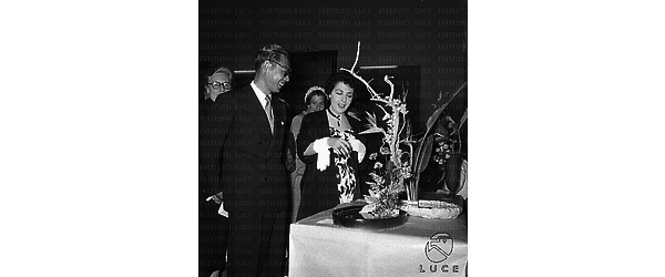 Un uomo orientale e una donna ammirano le sculture floreali esposte in mostra - piano americano