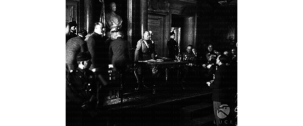 Roma Mussolini, in piedi dietro una cattedra in una sala del Campidoglio, mentre pronuncia il discorso inaugurale