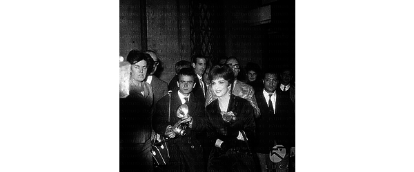 Gina Lollobrigida circondata da fans e fotografi; dietro di lei Bersani