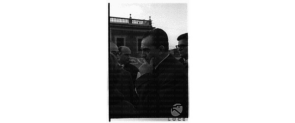 Luchino Visconti, Giovanni Testori, sul fondo, Enrico Lucherini, sulla destra e, di profilo Pietro Notarianni in piazza del Quirinale - medio primo piano