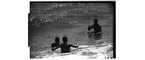 Ingrid Bergman e Rock Hudson (entrambi di spalle) fanno il bagno in mare a Santa Marinella con un altro uomo - campo lungo