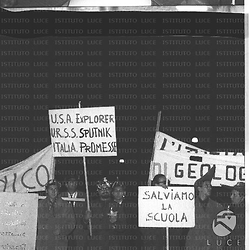 Un gruppo di studenti manifesta esibendo cartelli di protesta su cui si legge: 'U.S.A. Explorer, U.R.S.S. Sputnik, Italia Promesse'; 'Salviamo la scuola'. Piano medio