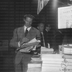 George Marshall sfoglia una rivista vicino ad un'edicola in via Veneto; piano americano
