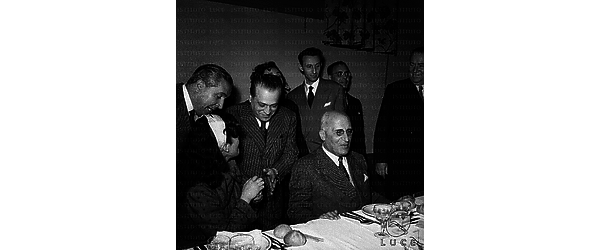 Roma Silvana Pampanini, seduta a tavola per un pranzo offerto ai parlamentari in visita a Cinecittà, saluta Tito Marconi e Gemini rivolti verso di lei