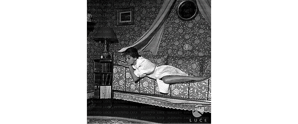 Parigi Claudia Cardinale in vestaglia sdraiata su un letto