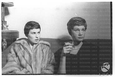 Silvana Mangano e Carla Gravina sedute sul divano in occasione del cocktail per il film Jovanka e le altre - piano medio