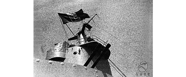 La torre di comando di una nave da guerra italiana, la bandiera italiana sventola, cannoni antiaerei puntati verso l'alto