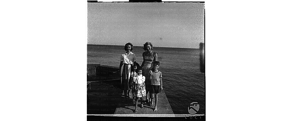 La Bergman con i figli su un pontile di S. Marinella. Campo medio