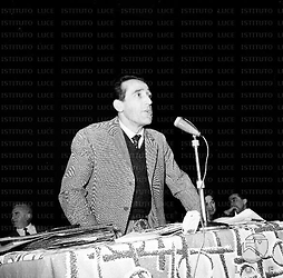 Arnoldo Foà interviene al microfono, alle sue spalle riconoscibili Vittorio Gassman e Gino Cervi