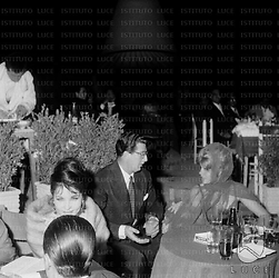 Roma Cristina Gaioni seduta ad un tavolo conversa con un uomo