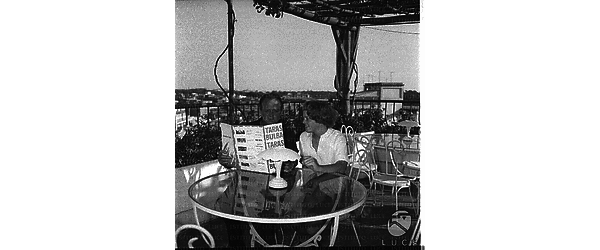 Van Heflin con una donna su una terrazza leggono una brochure del film 'Taras Bulba, il cosacco' - campo medio