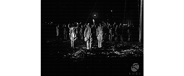 Orbetello Comandanti e equipaggi della crociera aerea Italia-Brasile fanno il saluto fascista durante la cerimonia notturna dell'alza bandiera, poco prima della partenza, all'idroscalo di Orbetello
