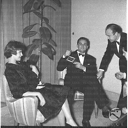 Anna Maria Ferrero e Vittorio Gassman seduti in poltrona in una sala. Totale