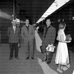 Il calciatore Bettini sulla banchina di una stazione; vicino a lui due uomini; si intravede un treno in sosta