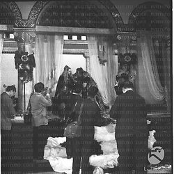 Alcuni fotografi, di spalle, riprendono Eleonora Rossi Drago e Jack Palance seduti su un trono sul set del film Rosmunda e Alboino - campo medio