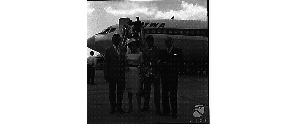 Jean Collins ripresa accanto a Richard Egan, ad un attore e a Raoul Walsh all'arrivo in aereoporto - piano medio