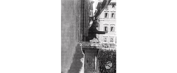 Roma Benito Mussolini, ripreso di profilo, è affacciato al balcone di Palazzo Venezia a Roma e sta arringando la folla sottostante