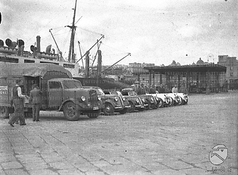 Napoli Alcuni piloti posano accanto alle loro auto da corsa, disposte in fila insieme ad un camion lungo una banchina del porto di Napoli per essere imbarcate