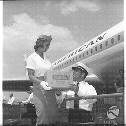 Una hostess della Pan Am con un pilota scaricano del latte in polvere per bambini malati - piano americano