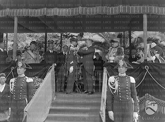Roma Mussolini premia un giovane carabiniere sul palco delle autorità durante la festa dei RR.CC. celebrata nella piazza d'armi della caserma "Vittorio Emanuele II" (oggi "Orlando De Tommaso")