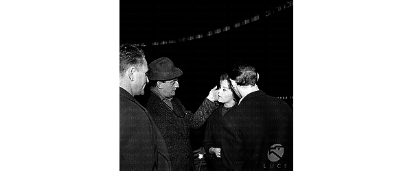 Milano Luchino Visconti, in esterni, di notte, con alcuni attori sul set del film Rocco e i suoi fratelli
