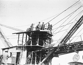 Lazio Mussolini colto sul tetto della cabina di comando di un escavatore meccanico utilizzato in una località in corso di bonifica dell'Agro Pontino