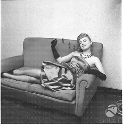 Ketty Della Porta sdraiata su un divano con una rosa in mano. Campo medio
