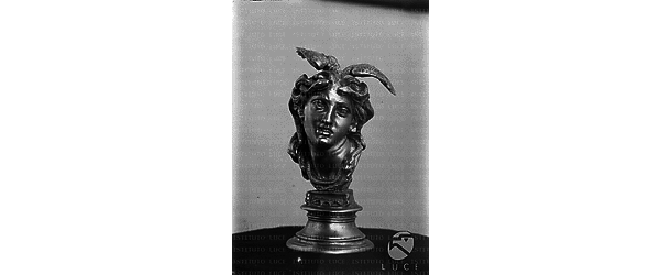 Testa alata in bronzo di Medusa su piedistallo, vista di fronte. Totale