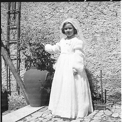 Una bambina con abito bianca per la prima comunione in un esterno. Totale