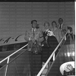 Dean Martin sulla scaletta dell'aereo, dietro di lui una donna, probabilmente la moglie - piano americano