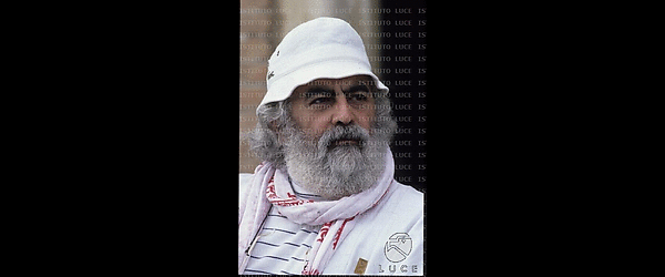 Armando Acosta (Baba Ganapati) vestito prevalentemente di bianco con cappello