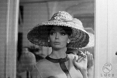 Barbara Steele ripresa in un negozio di cappelli mentre ne prova un tipo - piano medio