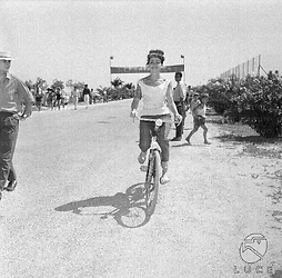 Giulia Rubini in bicicletta taglia il traguardo di una tappa del rally del cinema