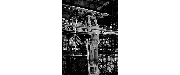 Padova Un operaio toglie dalla spalla di un collega, arrampicato su una scala, un sacchetto di sabbia da collocare su un'impalcatura