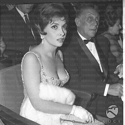 Gina Lollobrigida seduta in platea alla prima del film Ben Hur, accanto a lei probabilmente il direttore della Metro-Goldwin-Mayer - piano medio