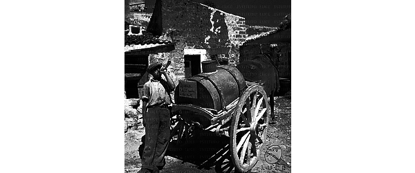 Sicilia Un uomo - incaricato della distribuzione e vendita di acqua al litro - richiama, attraverso il suono di un corno, i compratori d'acqua