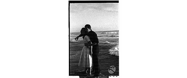 Gli attori Maurice Ronet e Marie Versini in piedi sulla battigia della spiaggia di Ostia - campo medio